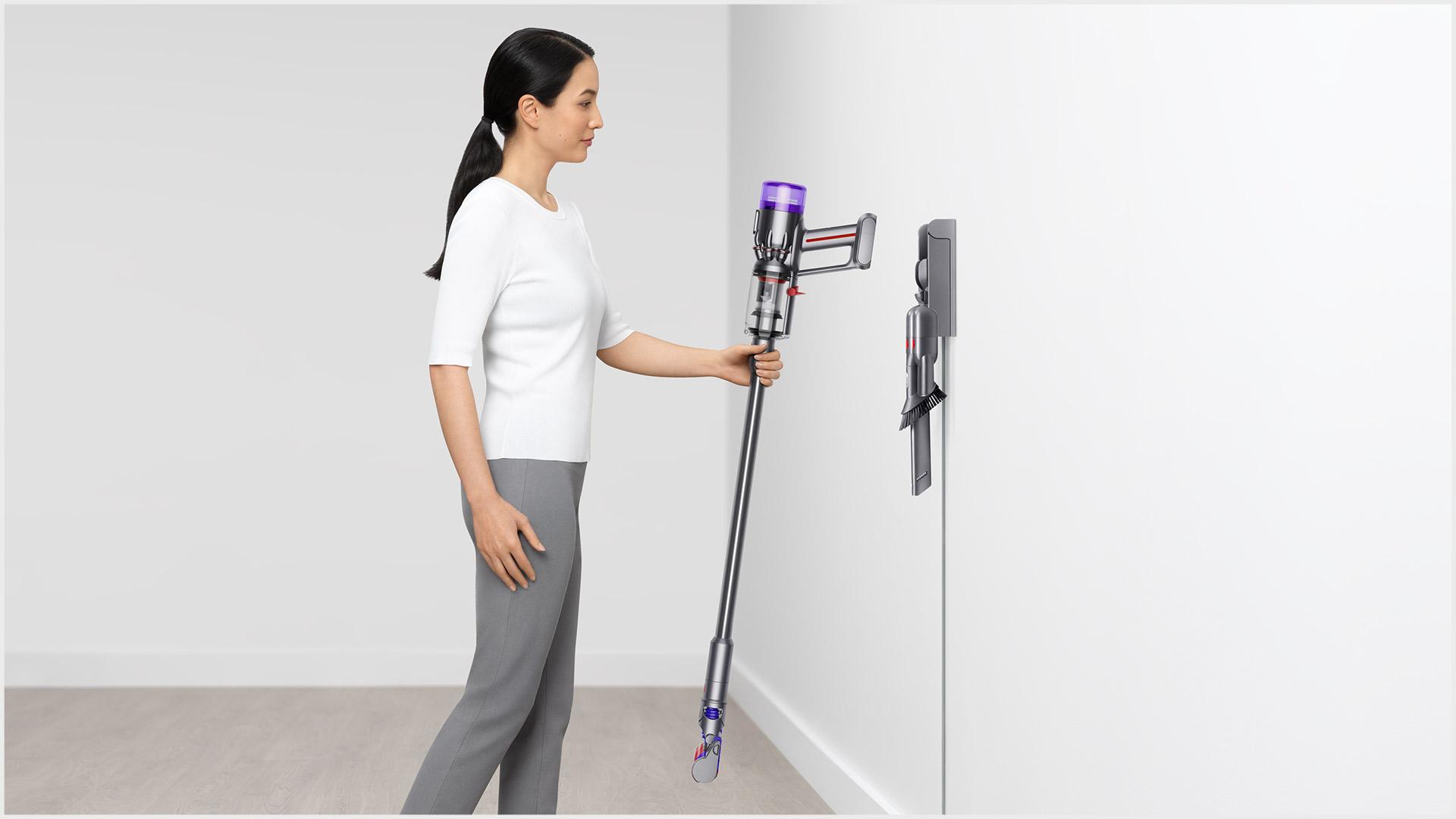 Woman placing vacuum into the wall dock