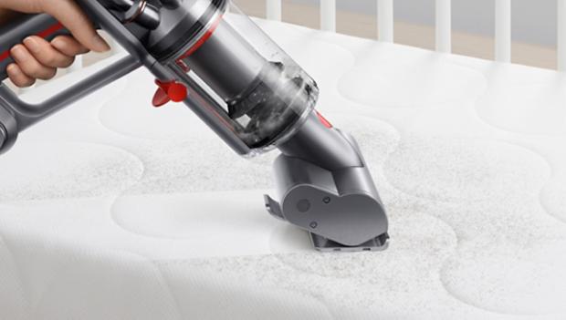 Dyson Micro 1,5 kg™ curățând prin aspirare o saltea