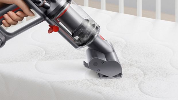 Dyson Micro 1,5 kg™ curățând prin aspirare o saltea