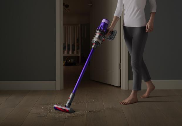 مكنسة Dyson Digital Slim™ بينما تقوم بتنظيف أرضية صلبة بجوار باب غرفة نوم.