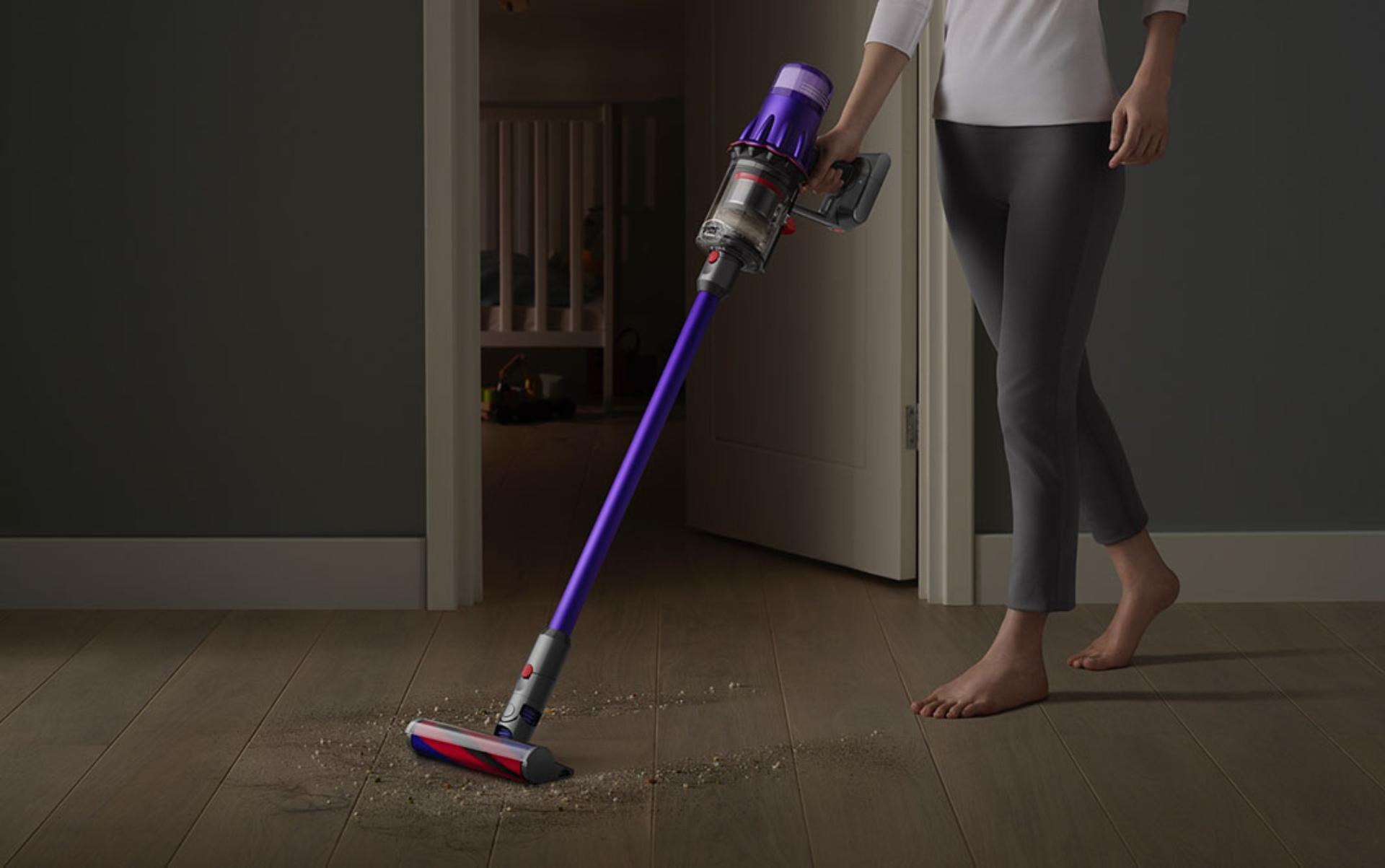 Dyson Digital Slim™ vacuum cleaning a hard floor by a bedroom door.