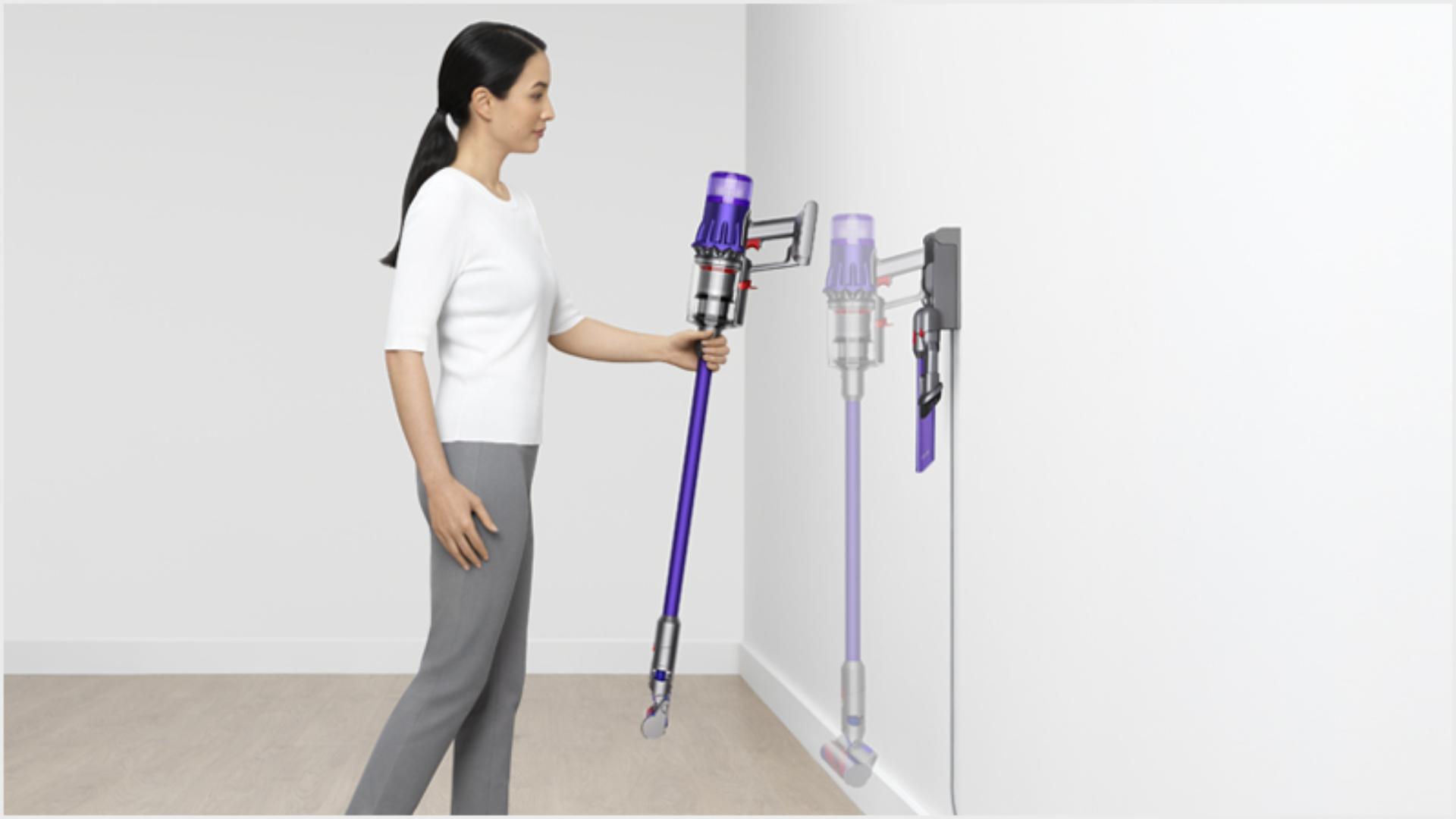 Woman dropping the Dyson Digital Slim vacuum into the wall dock