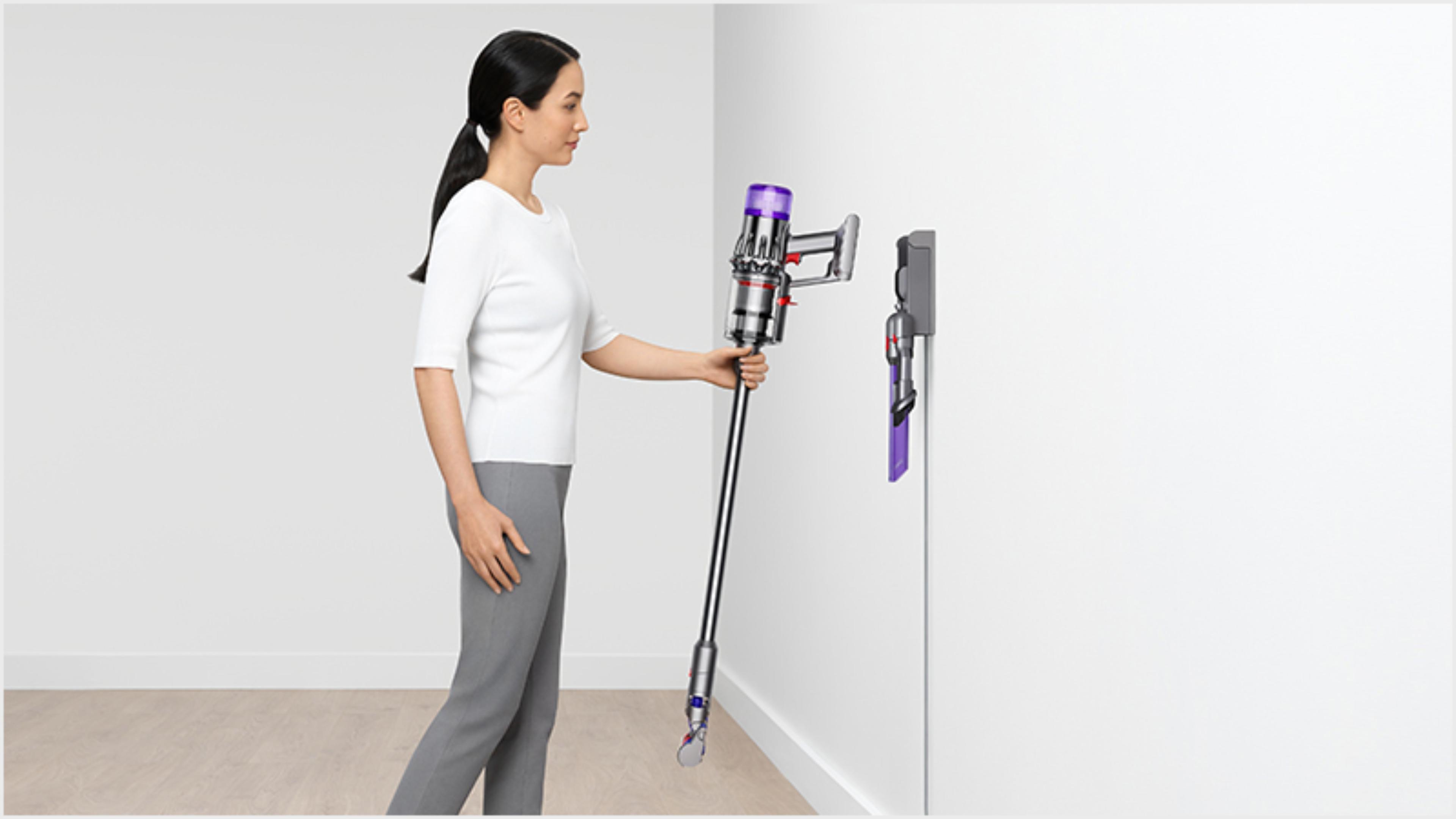 Woman dropping the Dyson Digital Slim vacuum into the wall dock