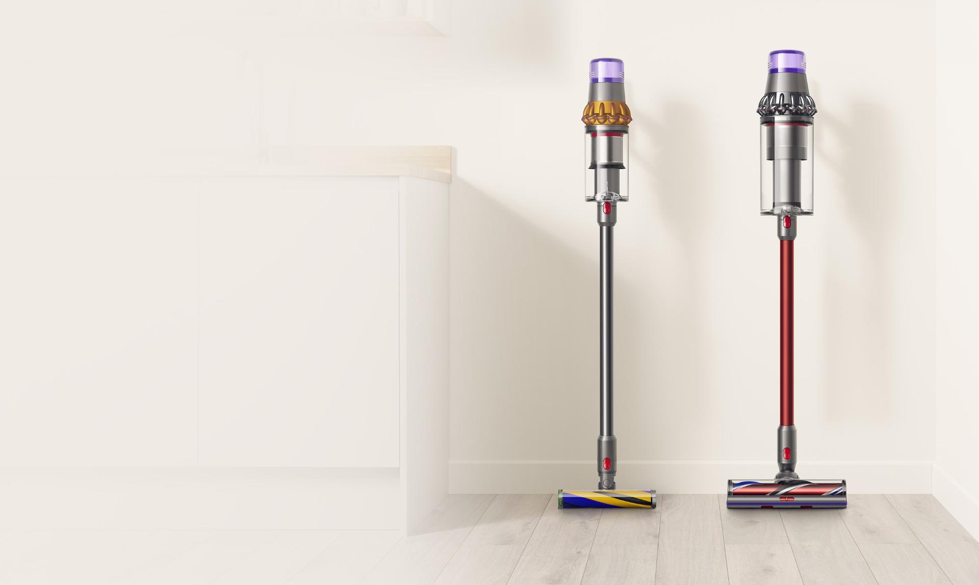 A Dyson V15 Detect cordless vacuum cleaner next to a Dyson Outsize cordless vacuum