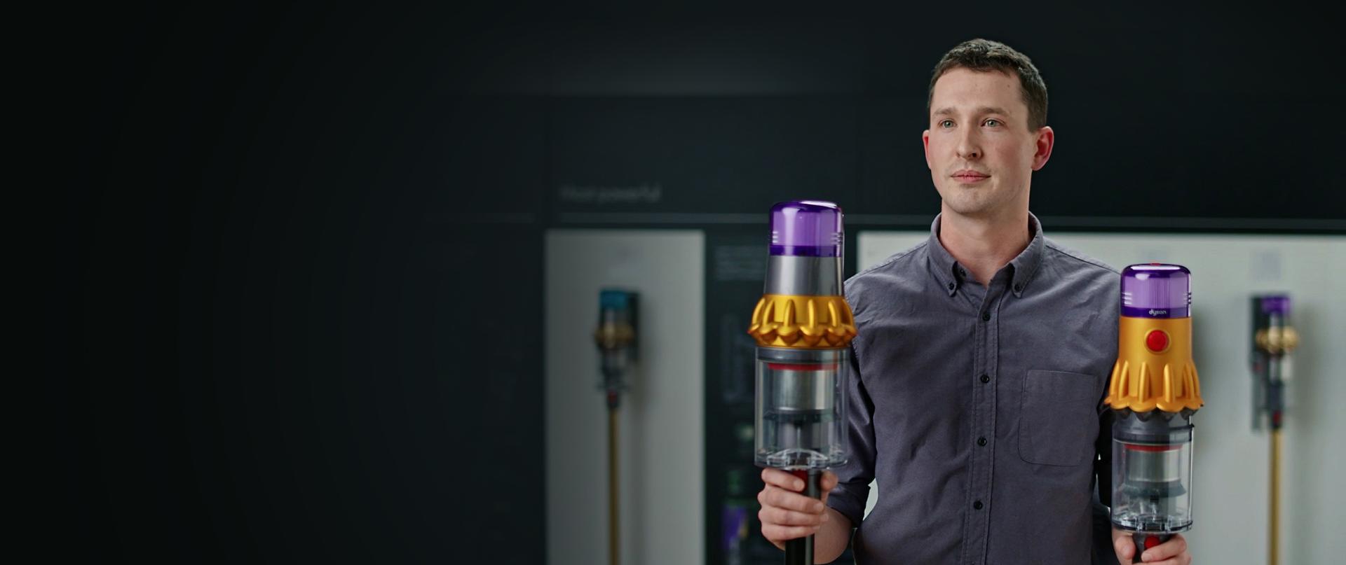 A Dyson Engineer holding Dyson V15 Detect and V12 Detect Slim vacuums