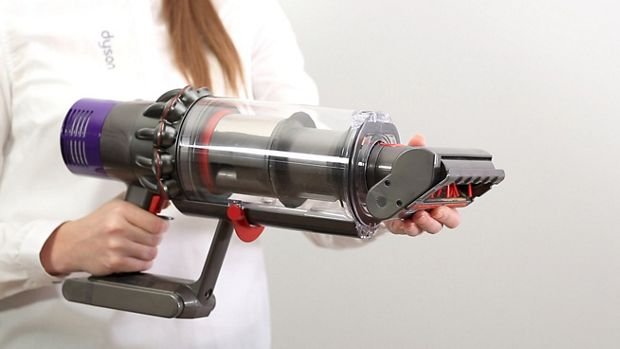 Osoba nakładająca mini elektroszczotkę zapobiegającą plątaniu bezpośrednio do odkurzacza