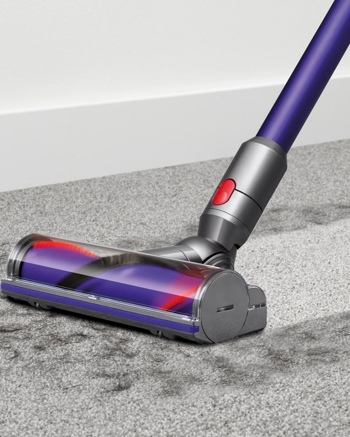 Dyson V10 Animal cordless vacuum cleaner picking up debris from carpet.