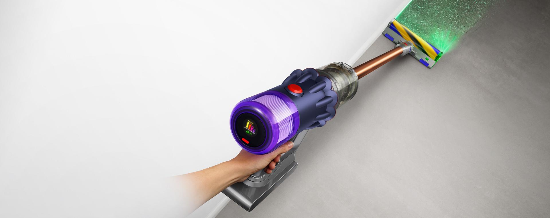 The Dyson V12 Detect Slim emitting a green blade of light from its Fluffy Optic cleaner head.