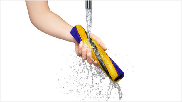 Person washing the Fluffy Optic brush bar under a tap