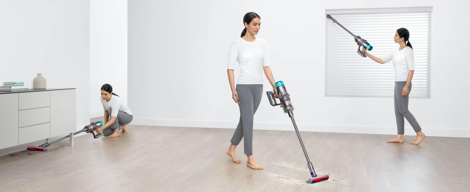 Kobieta odkurzająca podłogę, wnękę okienną i pod meblami w salonie.