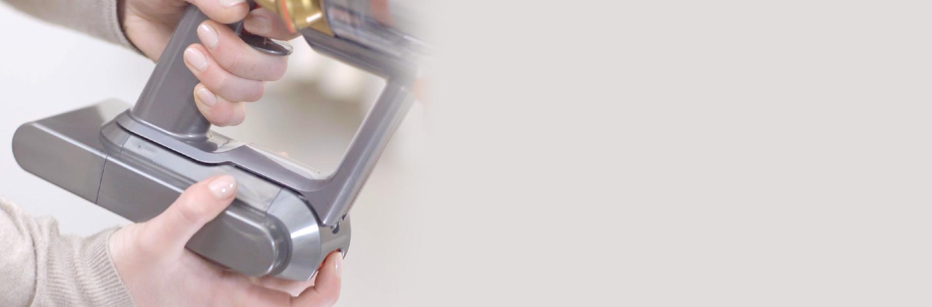 교체용 다이슨 배터리를 장착하고 있는 사용자.