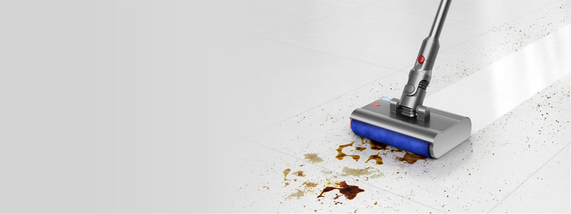 Submarine wet roller cleaner head removing a dirty spill from a hard floor.