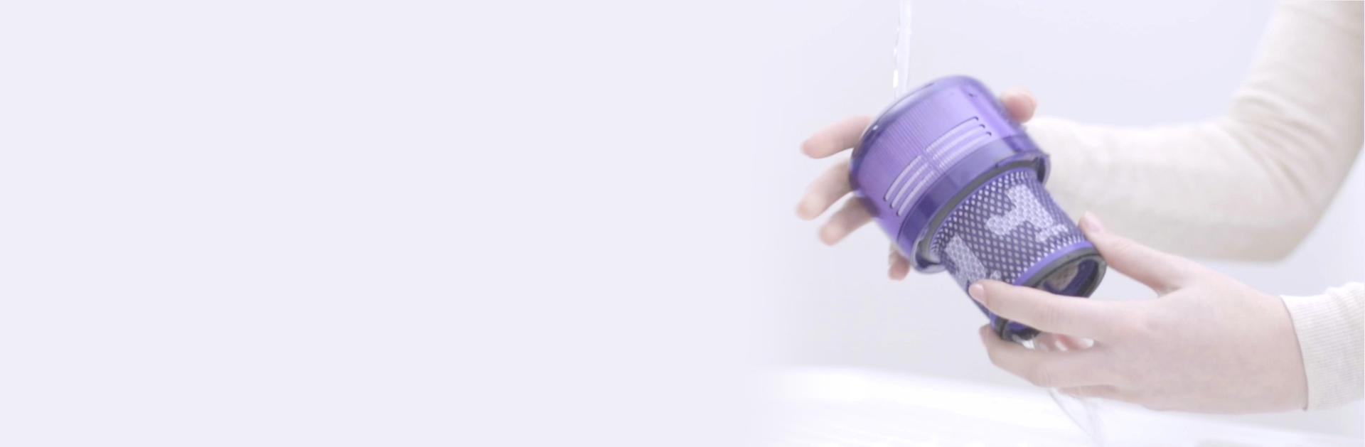 Video still of a user's hands washing the filter under a tap.