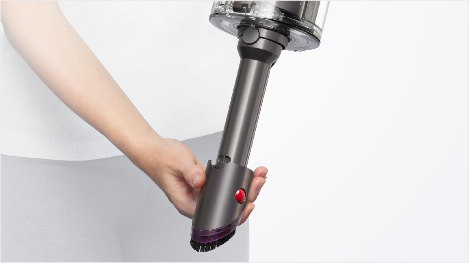 User detaching the wand to use the Built-in dusting and crevice tool.