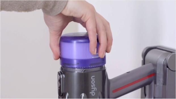 Video still of a user's hands washing the filter under a tap.