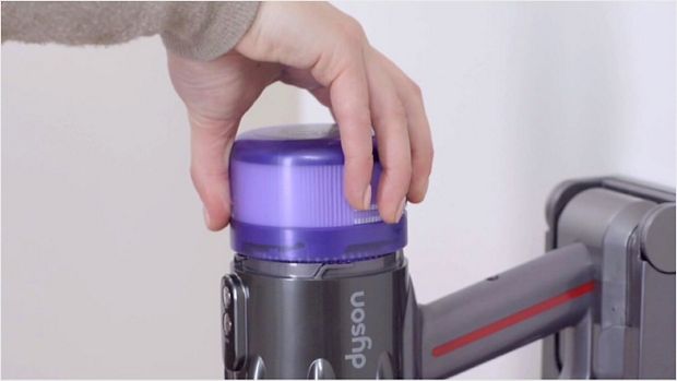 Video still of a user's hands washing the filter under a tap.