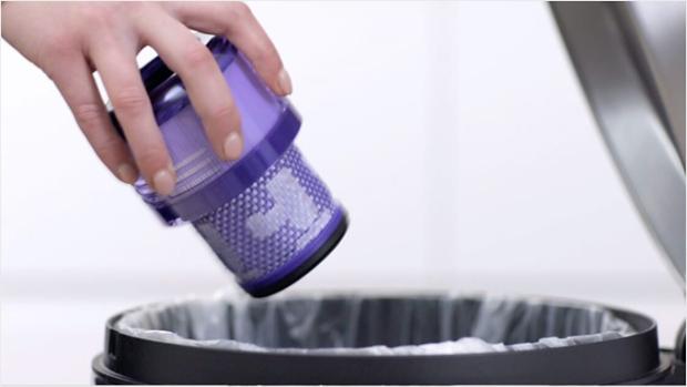 User tapping the filter to remove loose dust and debris.