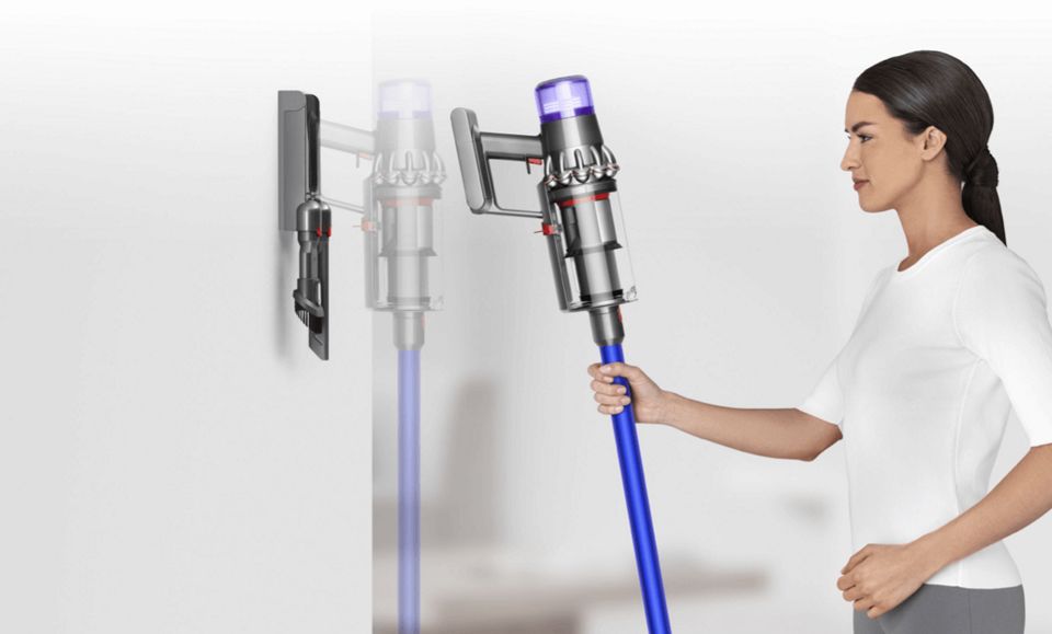 Žena ukládá vysavač Dyson V15 Detect do úchytu na stěně