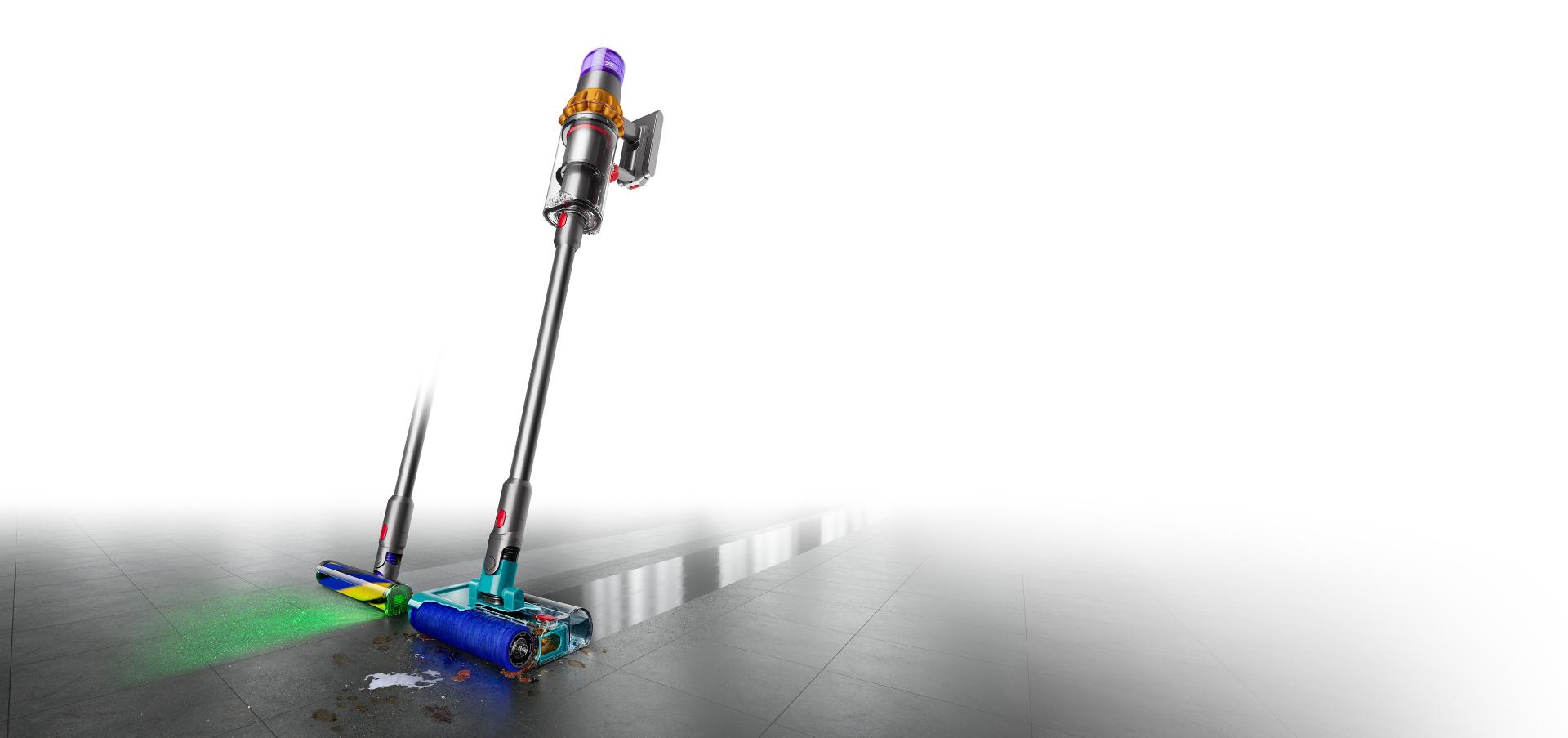 مكنسة Dyson V15s Detect Submarine المُزوَّدة بالرأس الأسطواني المُبلّل بينما تغسل أرضية صلبة. ويظهر رأس التنظيف الآخر خلفها.