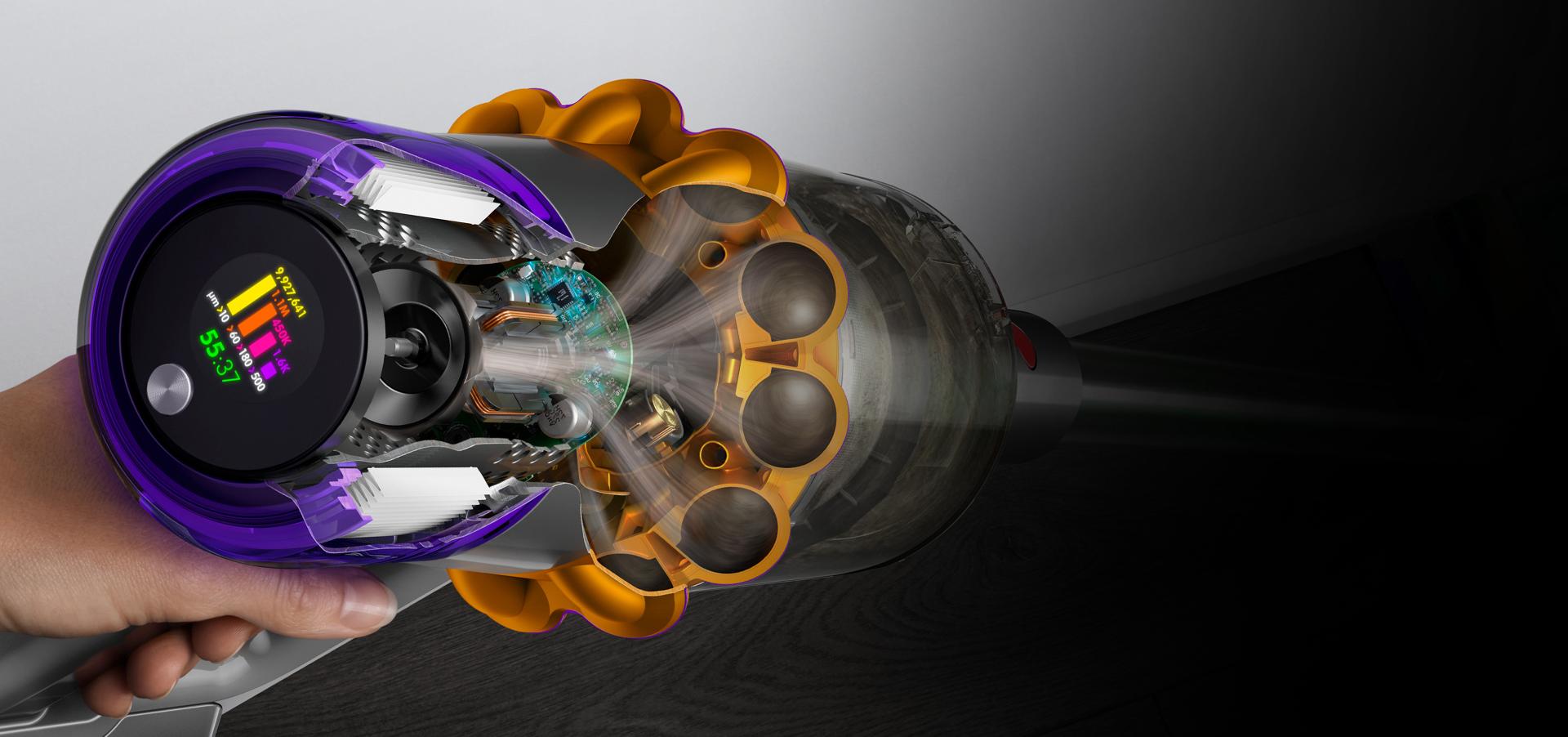 لقطة مقتطعة لجانب مكنسة Dyson V15s توضح المخلفات التي تتم فلترتها بينما تعرض شاشة LCD للمستخدم فترة التشغيل وأعداد الجسيمات.