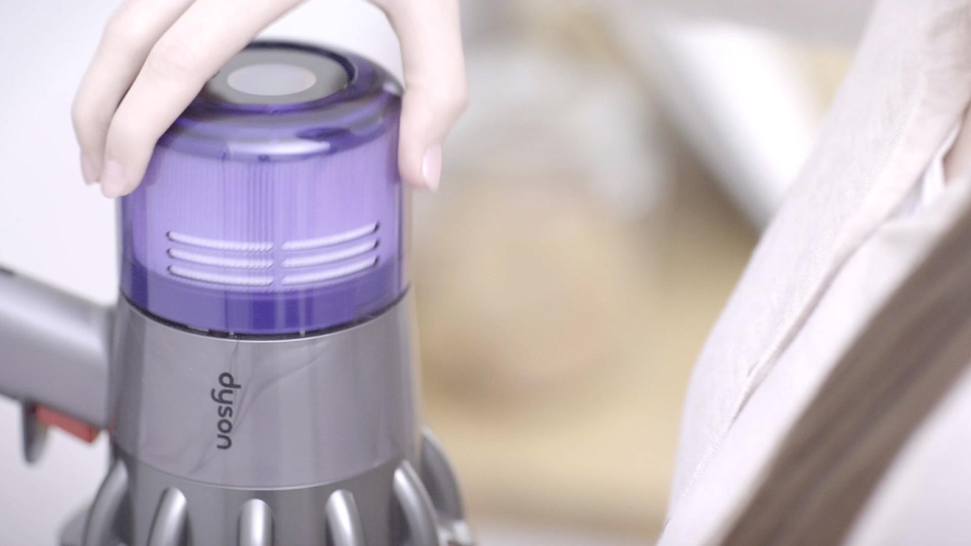 Użytkownik w trakcie przekręcania filtra w kierunku przeciwnym do ruchu wskazówek zegara celem wyjęcia go z korpusu odkurzacza.