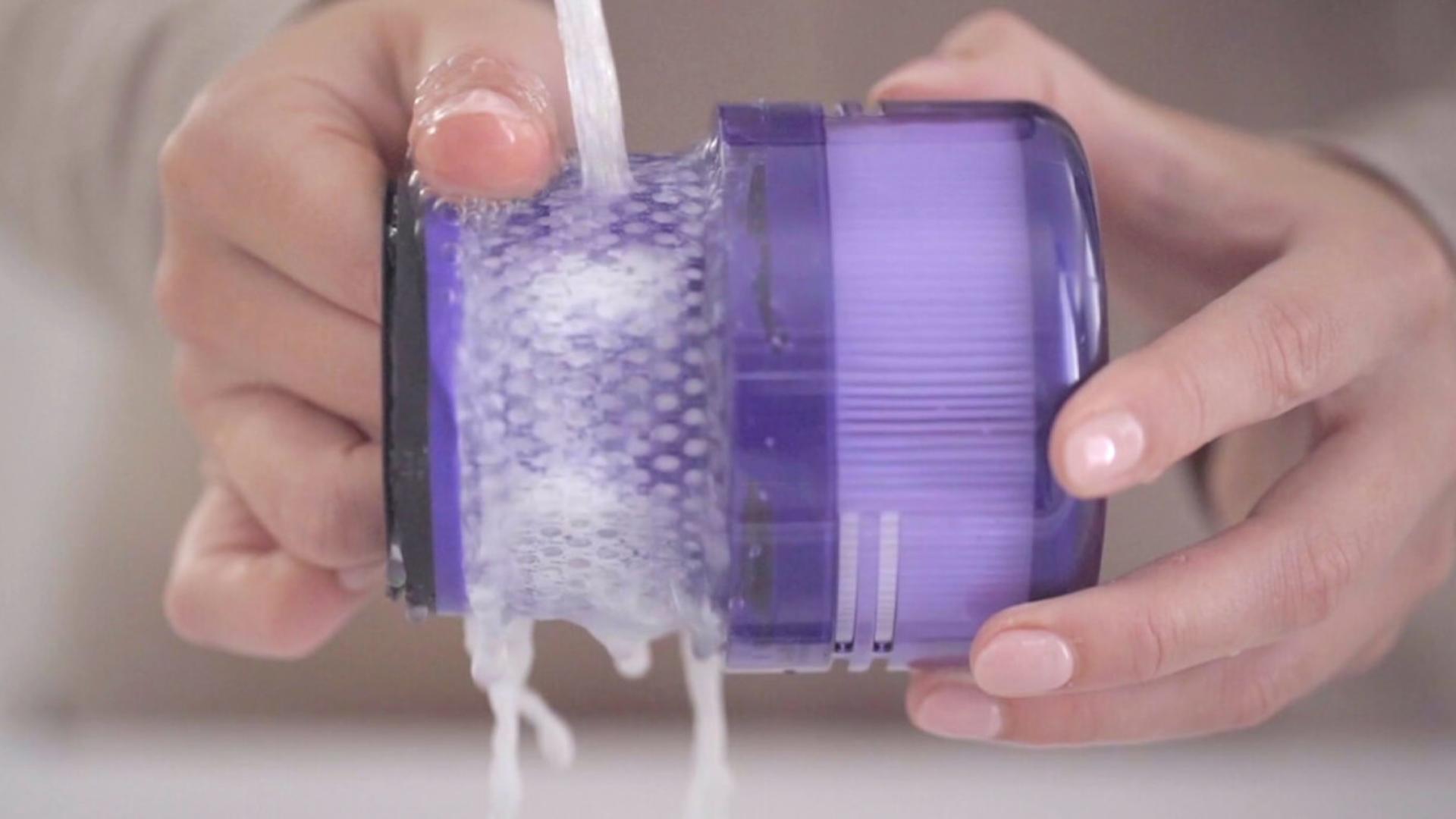 Użytkownik w trakcie mycia filtra pod wodą.