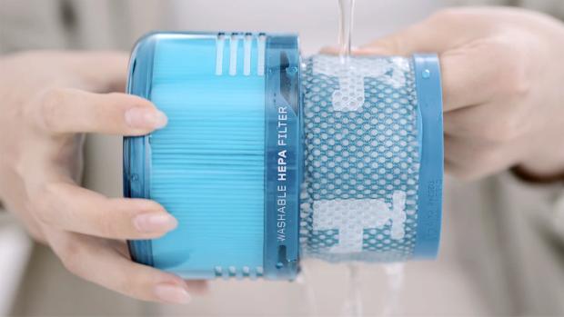 مستخدم يغسل الفلتر تحت الصنبور.