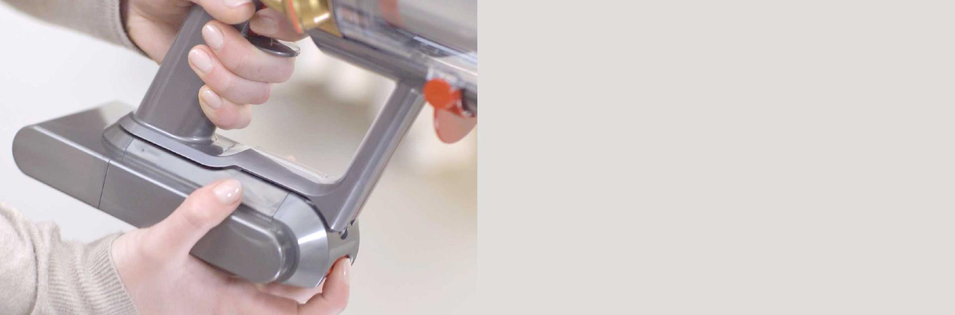 مستخدم بينما يقوم بتركيب بطارية دايسون بديلة.