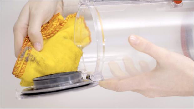 مستخدم يقوم بتنظيف حاوية المكنسة بممسحة.