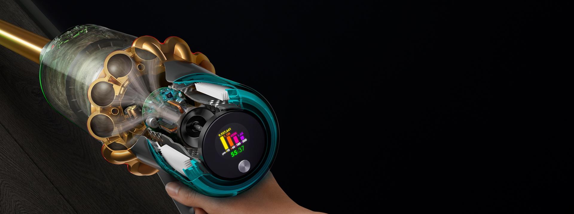 Vista seccionada lateral de una Dyson V15s que muestra los residuos filtrados y la pantalla LCD de usuario que muestra el tiempo de funcionamiento y el conteo de partículas.