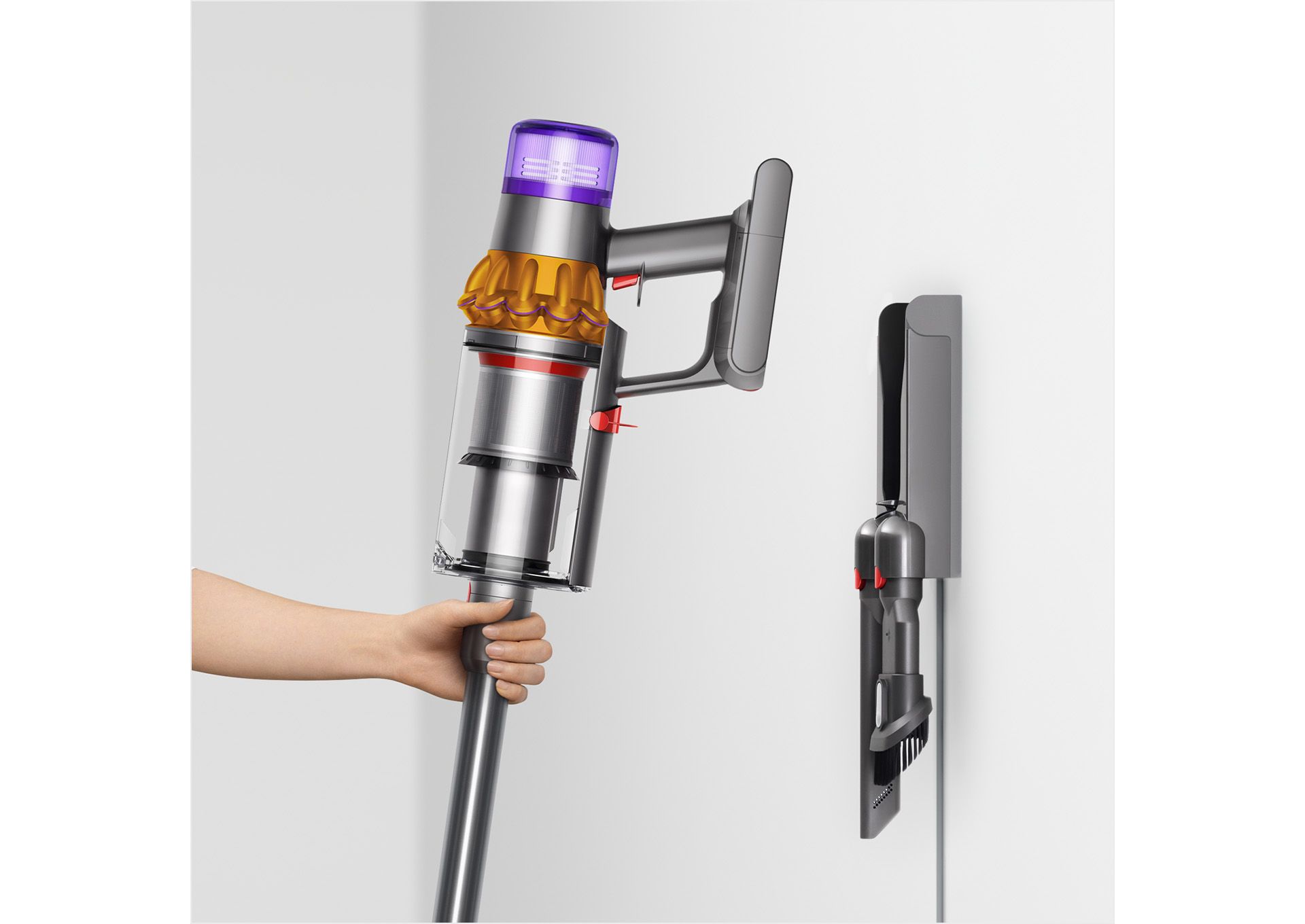 User placing Dyson V15s Detect Submarine wet and dry vacuum cleaner on to the wall dock.