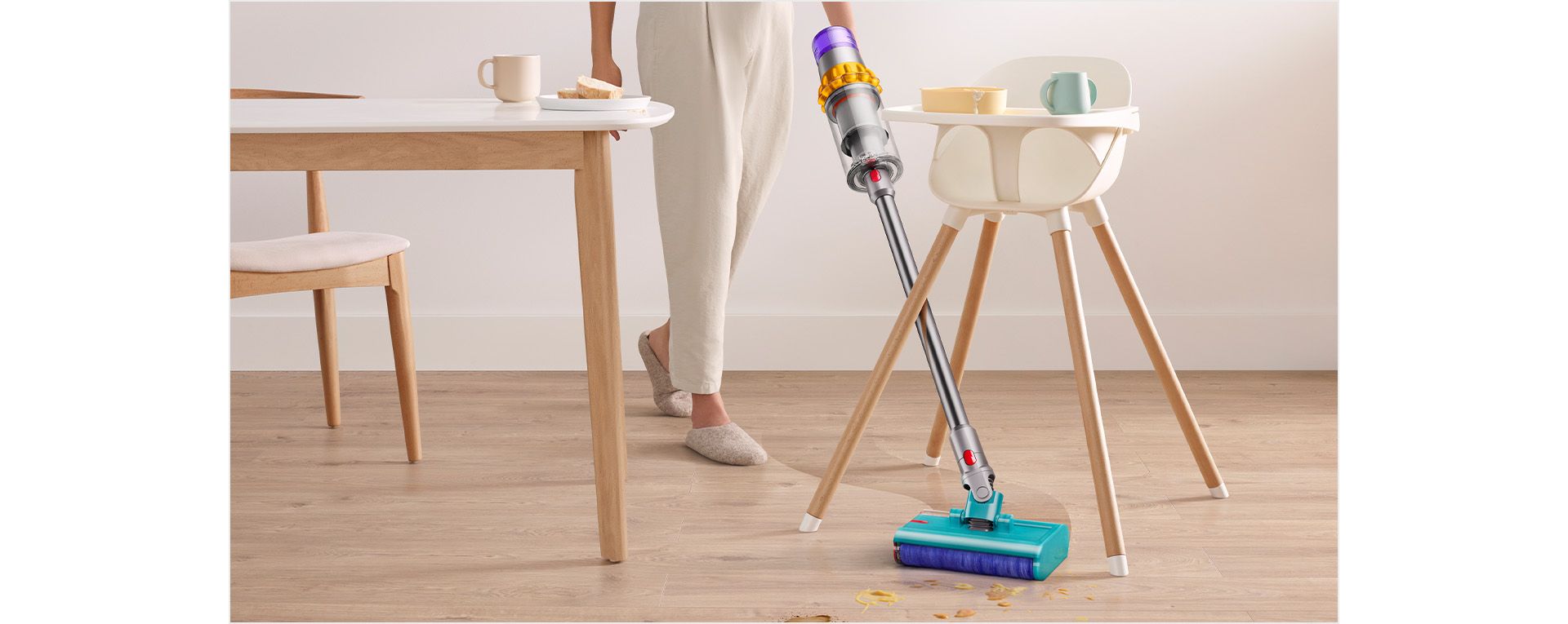 Dyson V15s Detect Submarine wet roller head angled in between a high chairs legs.