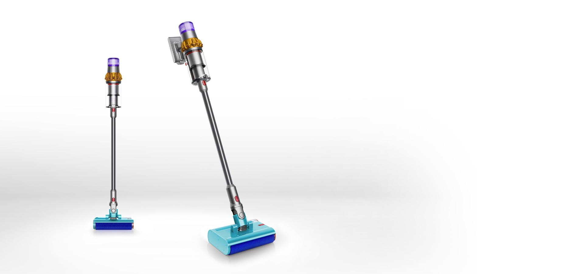 مكنسة Dyson V15s Detect Submarine المُزوَّدة بالرأس الأسطواني المُبلّل بينما تغسل أرضية صلبة. ويظهر رأس التنظيف الآخر خلفها.