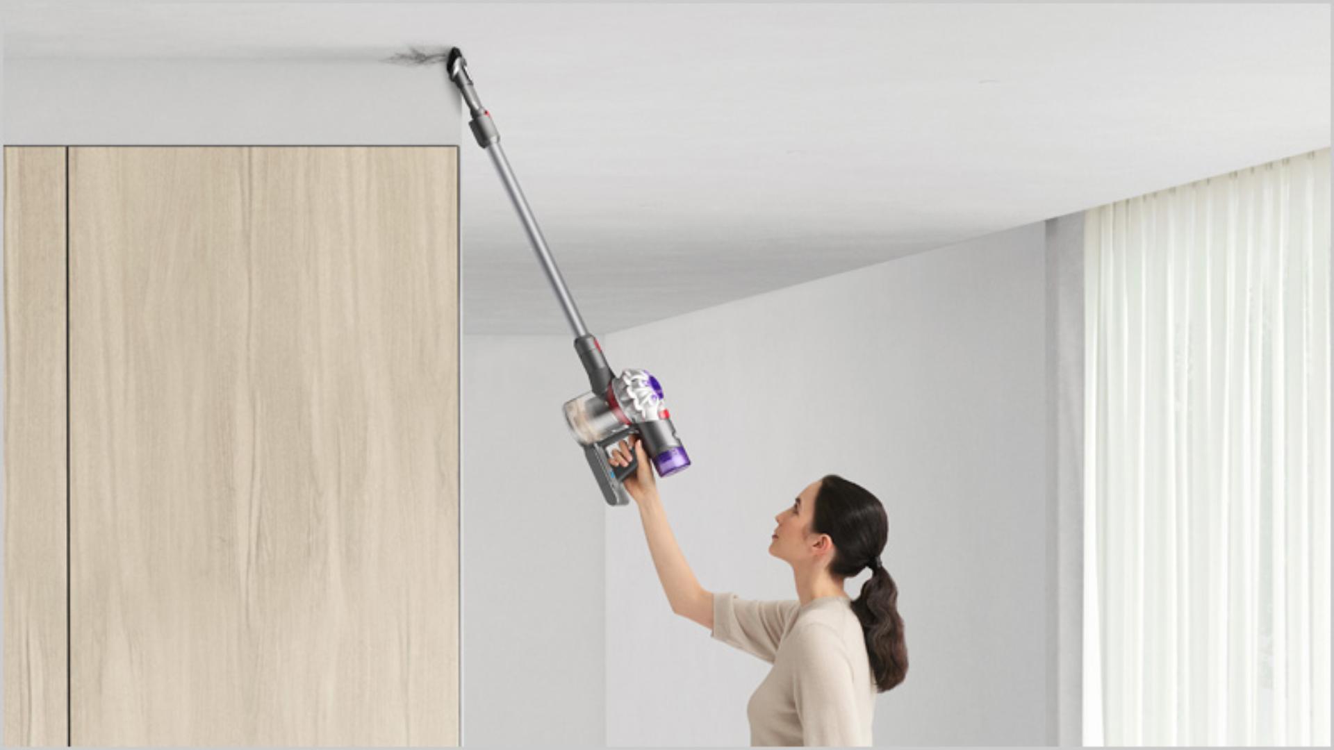 Woman cleaning up high with Dyson V7 Advanced vacuum