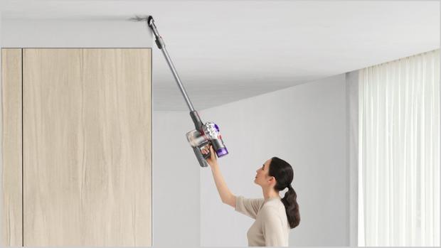 Woman cleaning up high with Dyson V7 Advanced vacuum