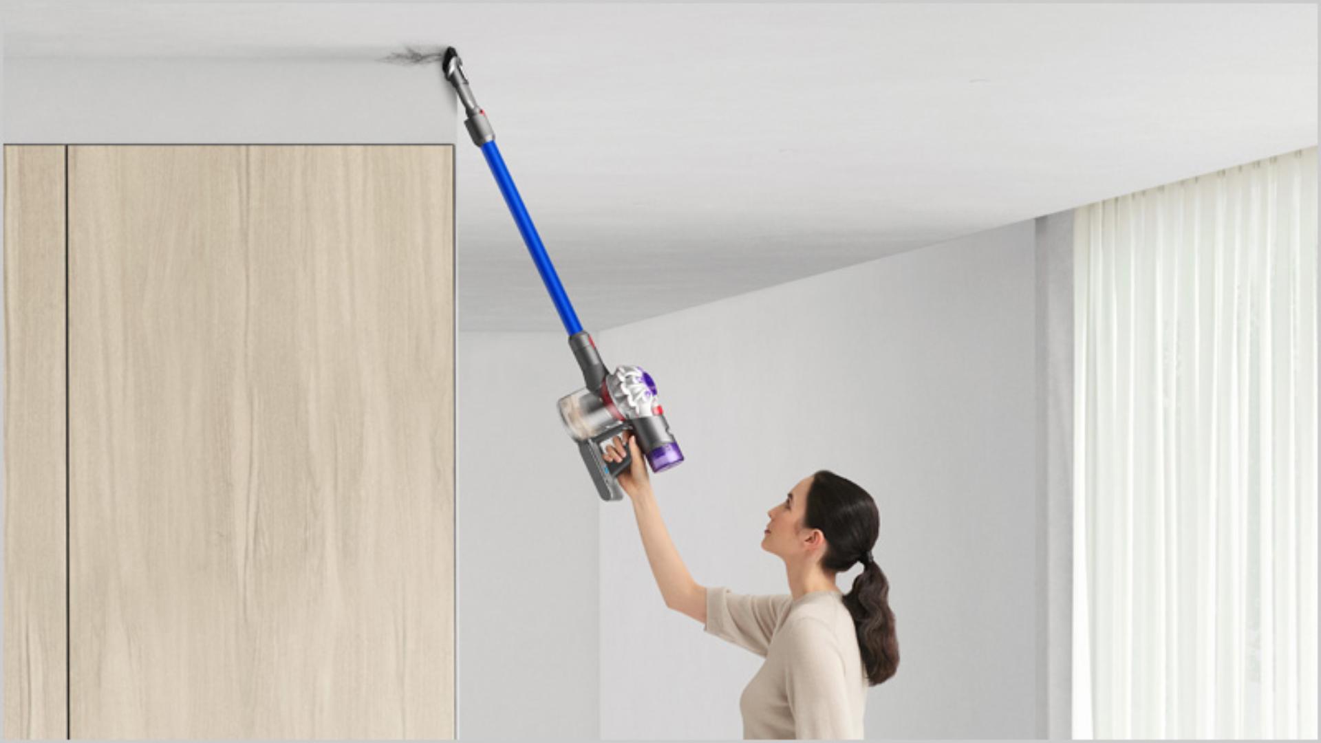 Woman cleaning up high with Dyson V7 Advanced vacuum
