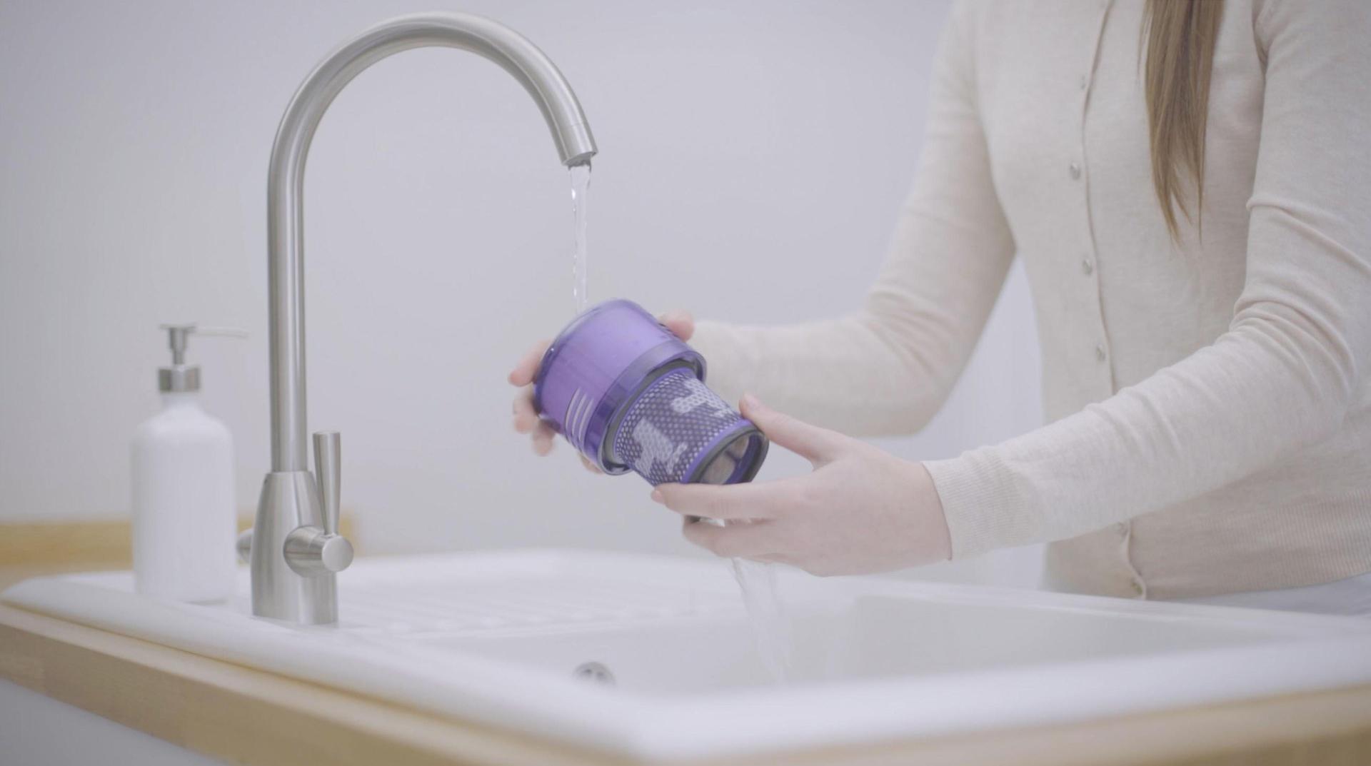 Lavaboda filtreyi yıkayan bir kadın