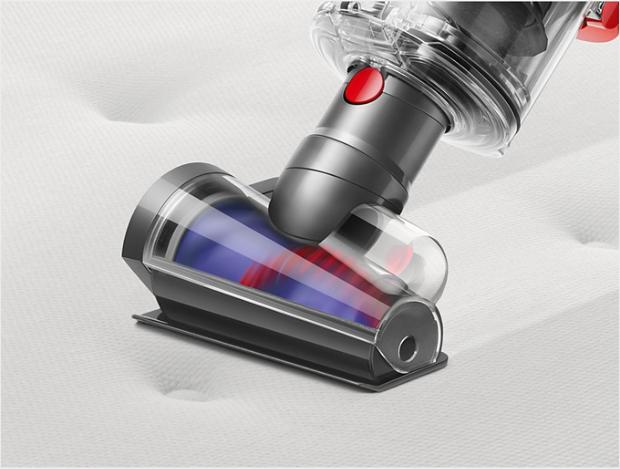 Hair screw tool vacuums along a beige carpet littered in hair and debris.