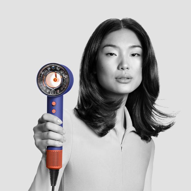 A model uses the Dyson Supersonic with Flyaway smoother attachment.