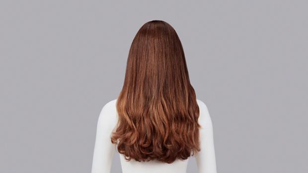 Naturally curly light brown hair styled with Dyson Chitosan Pre-style cream and the Dyson Airwrap. Seen from behind.