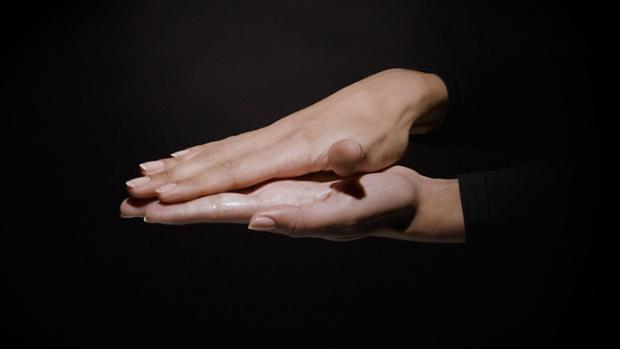 Dyson Chitosan Pre-style cream sheered between palms.