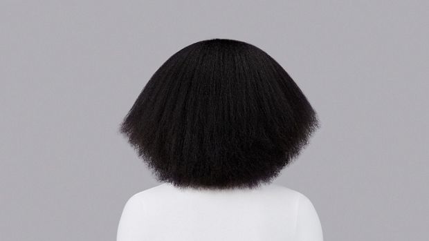 Naturally coily brown hair styled with Dyson Chitosan Pre-style cream and the Dyson Supersonic Nural. Seen from behind.