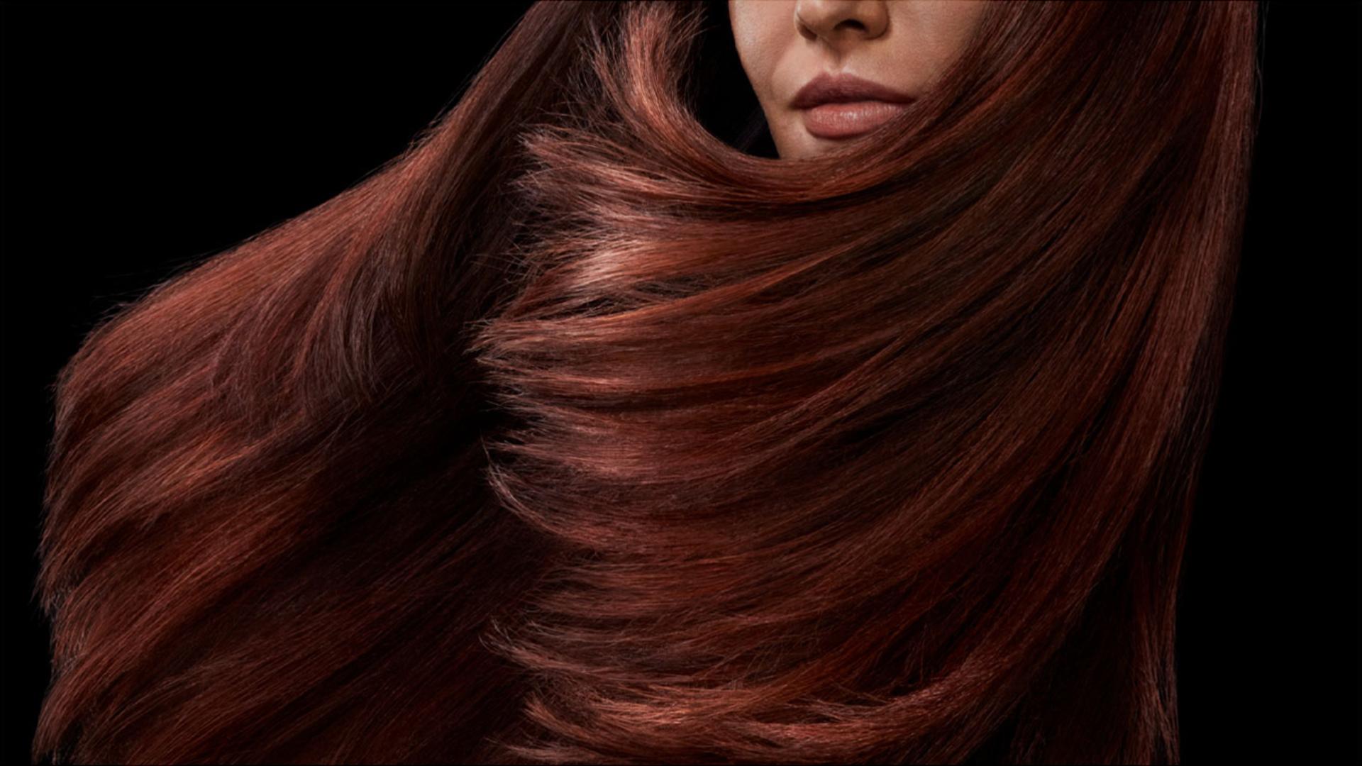Model with long, voluminous, shiny red hair.