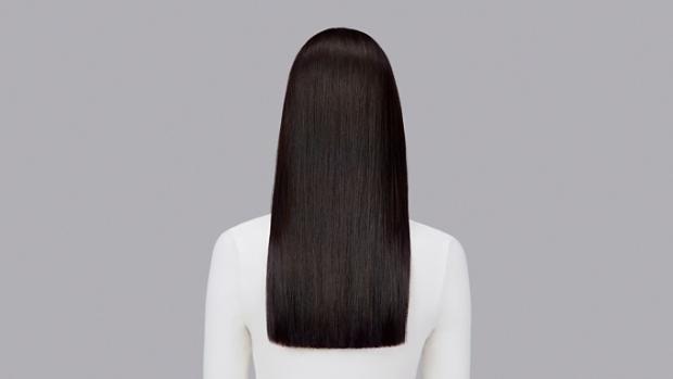 Naturally straight dark hair styled with Dyson Chitosan Pre-style cream and the Dyson Airstrait. Seen from behind.