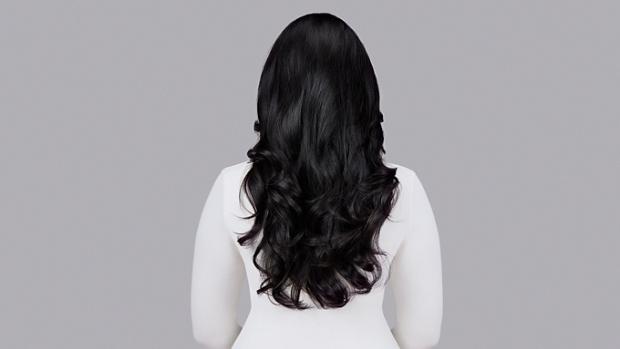 Naturally straight dark hair styled into waves with Dyson Chitosan Pre-style cream and the Dyson Airwrap. Seen from behind.