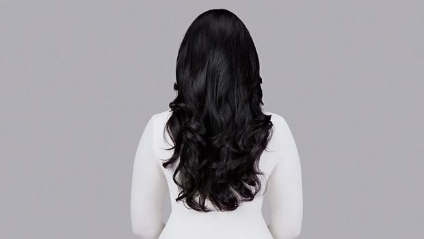Naturally straight dark hair styled into waves with Dyson Chitosan Pre-style cream and the Dyson Airwrap. Seen from behind.