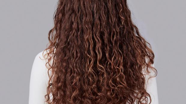 Model with long curly brown hair.