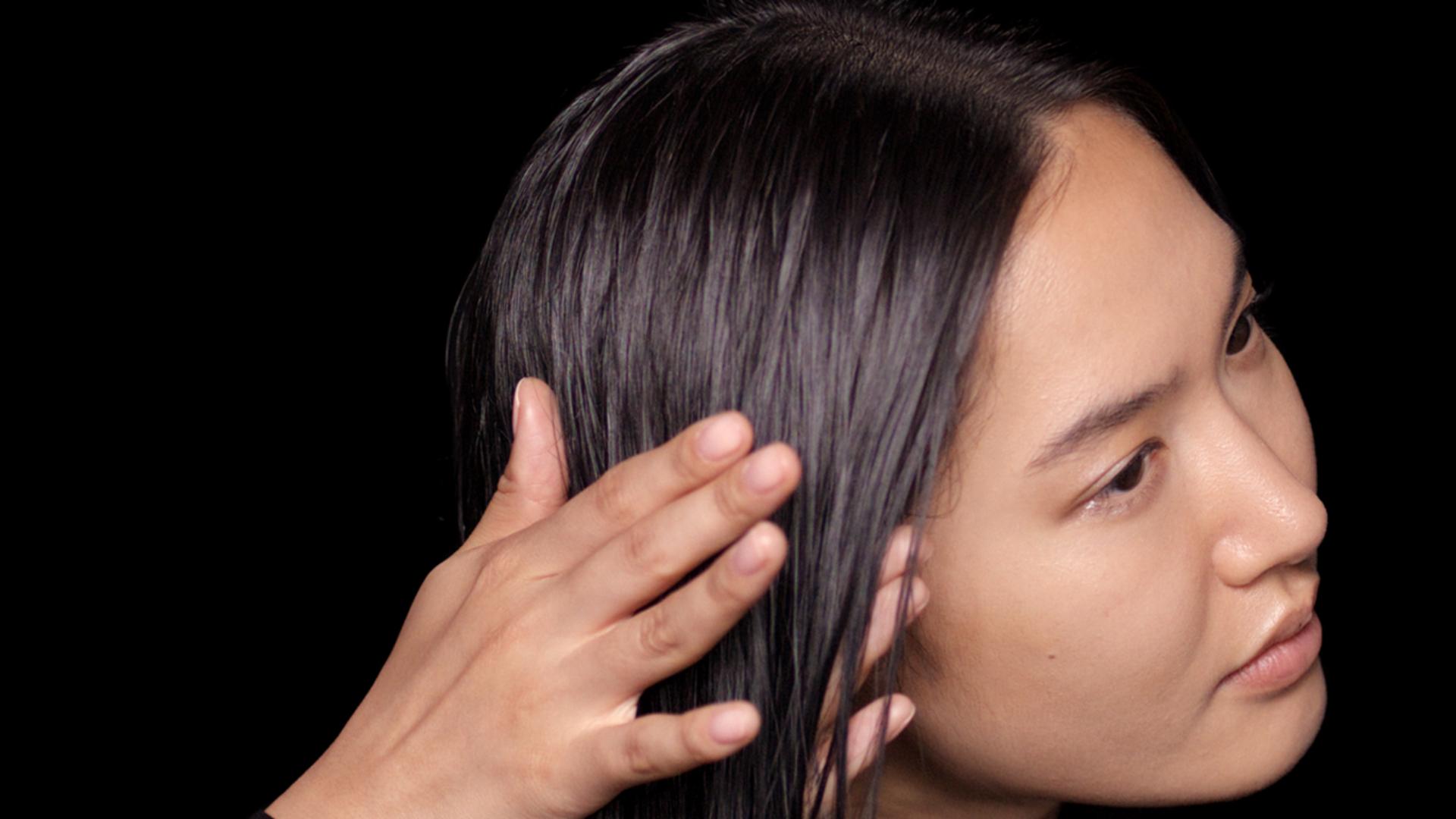 Dyson Chitosan Pre-style cream smoothed between palms and hair.