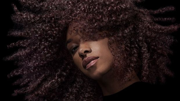 عارِضة تقوم بتحريك شعرها البني الملفوف لإبراز ثباته.