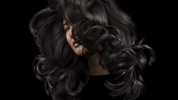 Model with long, voluminous, shiny black hair.